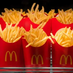 Kilka czerwonych opakowań frytek z logo McDonald's.