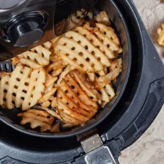 Frytki kratkowane w koszu frytkownicy beztłuszczowej.