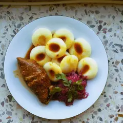 Talerz z kluskami śląskimi, roladą i czerwoną kapustą.
