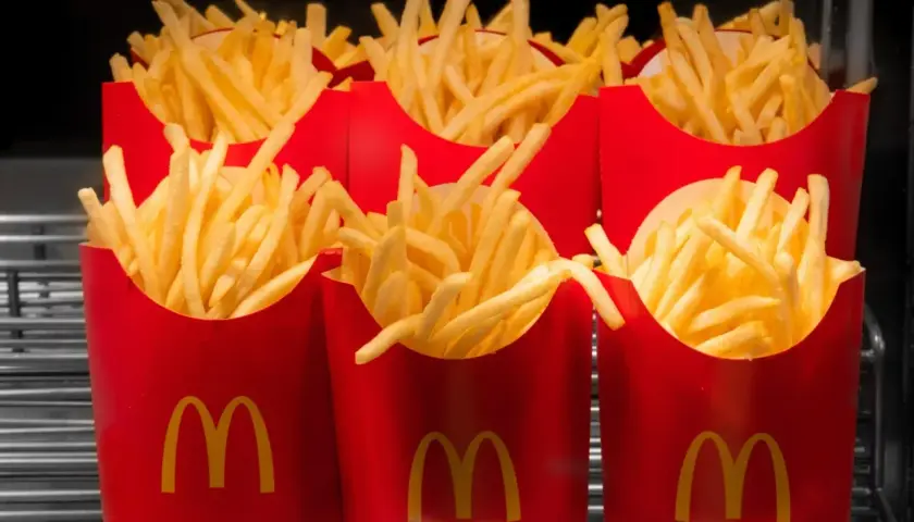 Kilka czerwonych opakowań frytek z logo McDonald's.